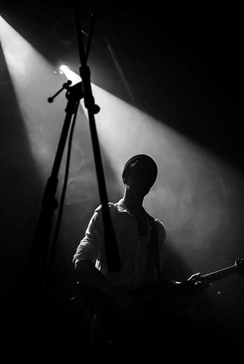 Coast of Madness Bassist im Gegenlicht, sein Gesicht ist im starken Kontast nicht zu sehen